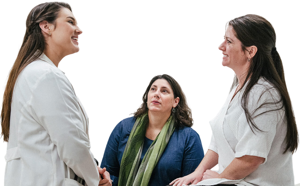 A woman with a companion meeting with a medical professional.